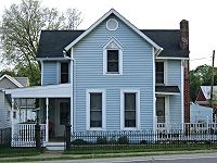 The house I grew up in was old when I lived there, but it was between two older homes with more history. When the Races lived there, the house had pale gray asbestos siding and a shakey balcony on the right side. Later owners added blue vinyl siding, removed the balcony (for safety reasons, I'm sure), and expanded both porches. Click for bigger photo.